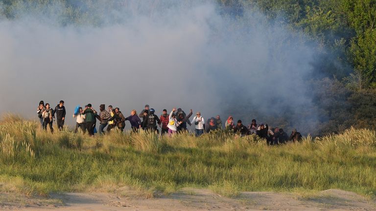 Lidé považovali za migranty, kteří se vynoří z keřů na pláži ve Francii ve Francii poté, co francouzské úřady vypálily slznou plyn. Datum obrázku