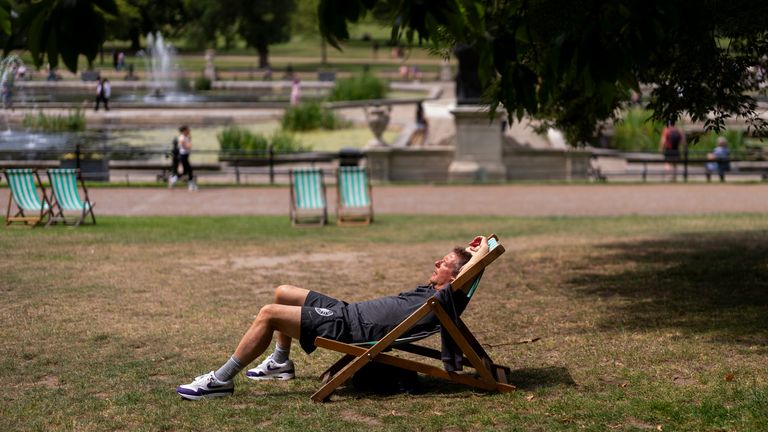Lidé opalují na palubě židle Kensington Gardens.  Pic pa
