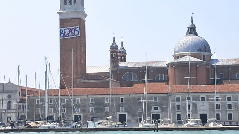 Anti Jeff Bezos znak visel protestujícími na zvonici ve věži San Giorgio Maggiore Basilica. Pic: Federica Toninelli