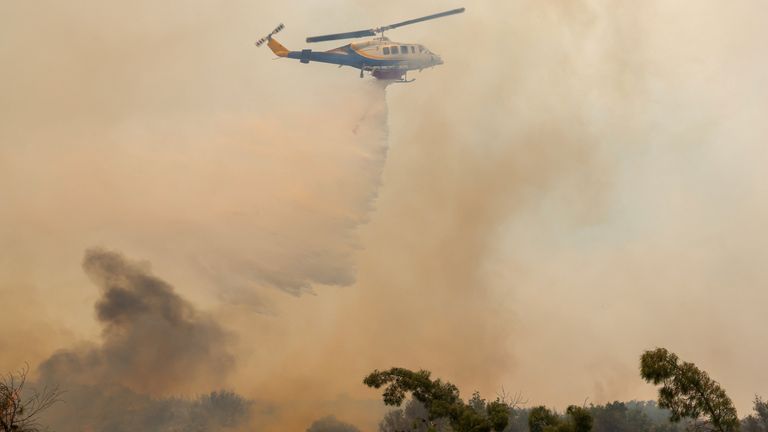Vrtulník způsobuje pokles vody, když požár požáru poblíž vesnice Agios Georgios Sikousis na ostrově Chios v Řecku.  Pic: Reuters