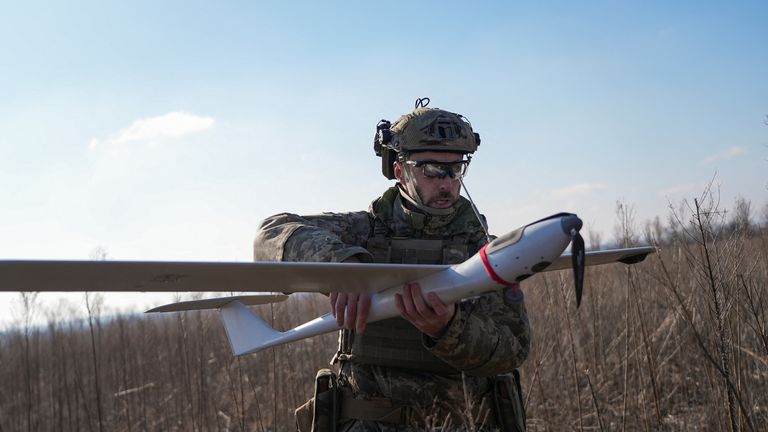 Ukrajinský bojovník nese dron poblíž města Lyman v oblasti Doněcku. Pic: Reuters