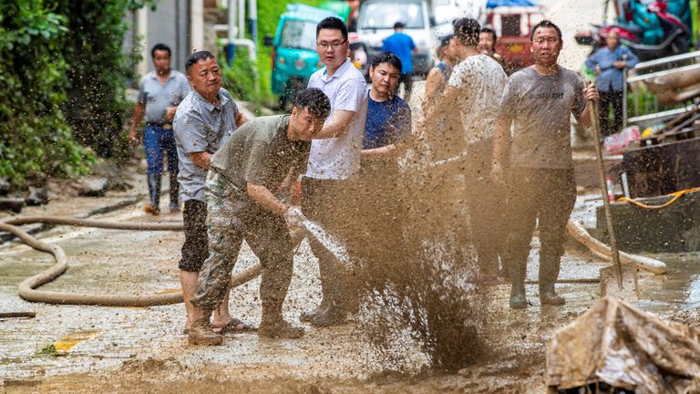Obyvatelé čistí bláto po povodní v kraji Congjiang, Qiandongnan Miao a Dong Autonomous Prefecture, Guizhou provincie, Čína 25. června, 