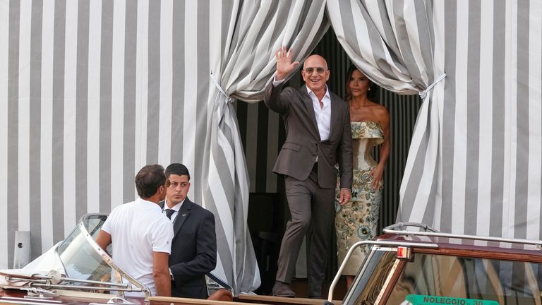 Jeff Bezos, střed vlevo a Lauren Sanchez, vpravo, opustí hotel pro jejich před svatební hostinu, v Benátkách, Itálie, čtvrtek 26. června 2025. (AP Photo/Luca Bruno)