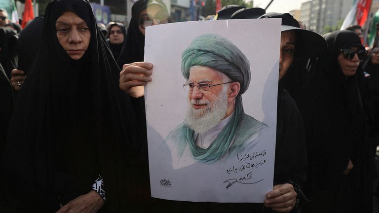 Žena drží obrázek íránského nejvyššího vůdce Ayatolláha Ali Khameneiho, když se účastní pohřebního průvodu v Teheránu.  Pic: Reuters
