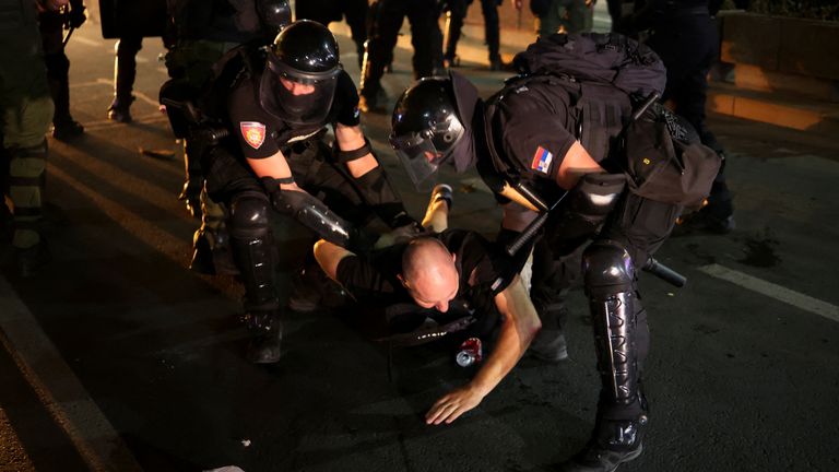 Úředníci činní v trestním řízení zadržují demonstrátora během protivládního protestu. Pic: Ap