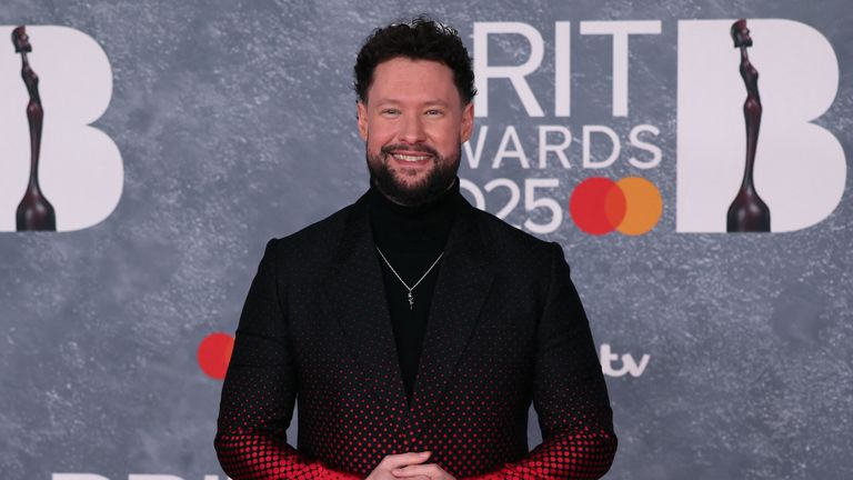Calum Scott v černé a červené barvě plus krk želvy pro dobrou míru. 