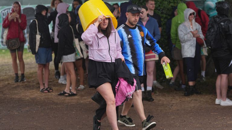 Revelers na festivalu Glastonbury během sprchy.  Pic: Reuters