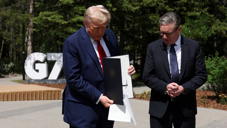 Americký prezident Donald Trump drží podepsanou obchodní dohodu ve Velké Británii-USA během setkání s britským premiérem Keirem Starmerem na summitu G7 v Kananaskis v Albertě v pondělí 16. června 2025. (Suzanne Plunkett/Pool Photo přes AP)