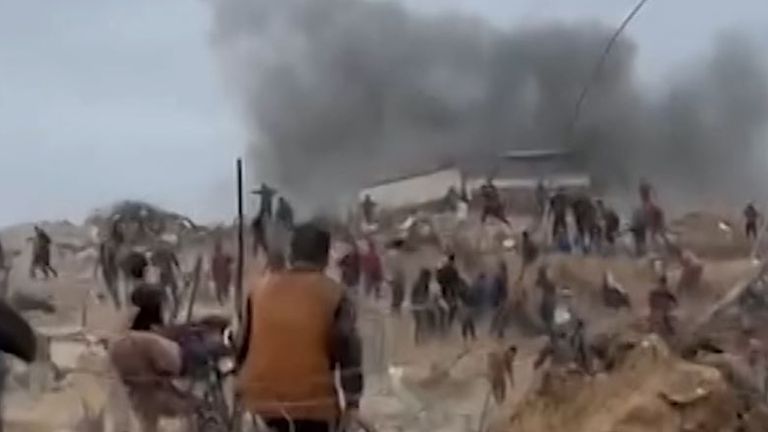 Palestinci běhají z výbuchu, když se dostali do centra distribuce potravin
