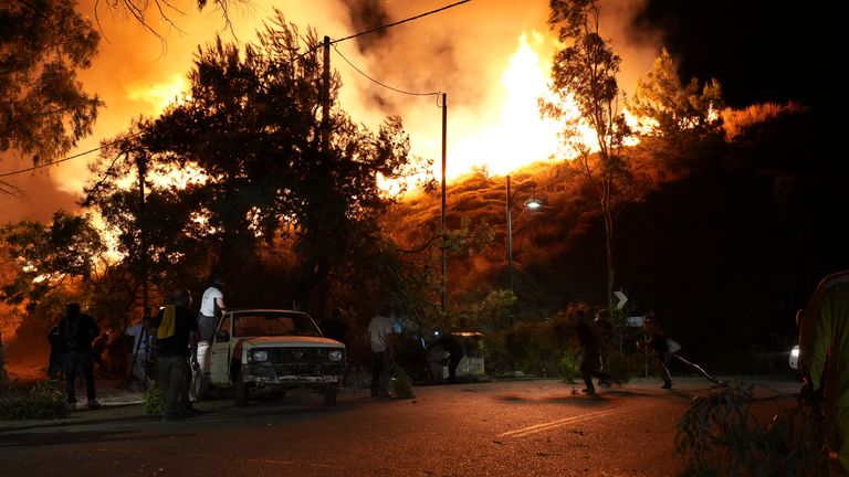 Místní obyvatelé sledují, jak se v Kofinasu blíží k požáru na východním Egejském ostrově Chios v Řecku.  PIC: Politischios.gr /ap
