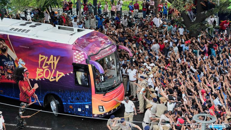 Fanoušci povzbuzují, když autobus nesoucí kriketové krikety Bengaluru dorazí na stadion M. Chinnaswamy. Pic: Ap
