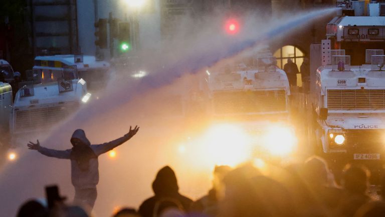 Policie zaměřuje vodní dělo u demonstrantů, protože nepokoje pokračují v Ballymeně. Pic: Reuters
