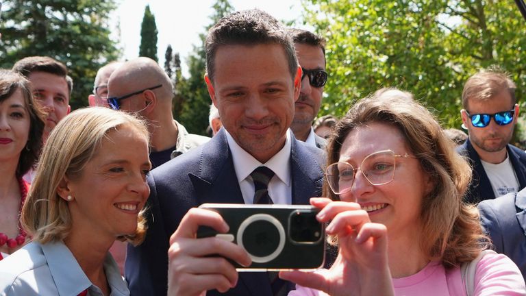 Rafal Trzaskowski představuje pro selfie a zanechá volební stanici se svou ženou Malgorzata Trzaskowskou. Pic: Ap