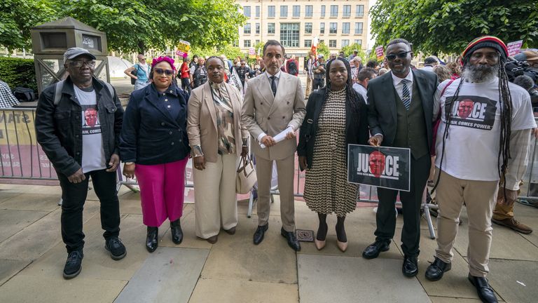 Advokát Aamer Anwar spolu se sestrami a příznivci Sheku Bayoh mimo hlavní dům v Edinburghu, před dvoudenním soustředěním