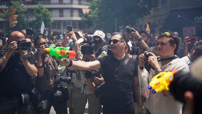 Lidé střílejí směrem k turistům s vodními zbraněmi během protestu proti překračování v Barceloně ve Španělsku. Pic: Ap