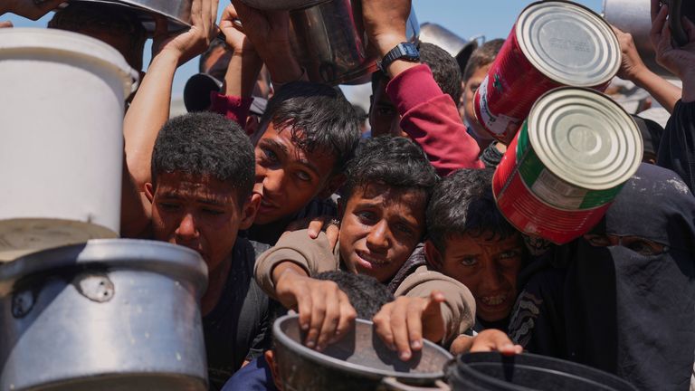 Palestinci se snaží v pondělí získat darované jídlo v komunitní kuchyni v Khan Younis. Pic: Ap