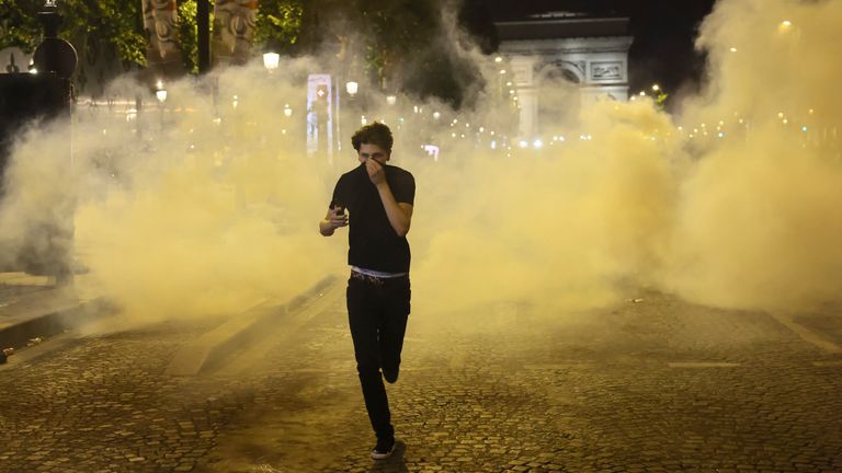 Muž utíká z Teargasů během incidentů na Champs Elysees Avenue poté, co PSG vyhrál Ligu mistrů. Pic: Ap