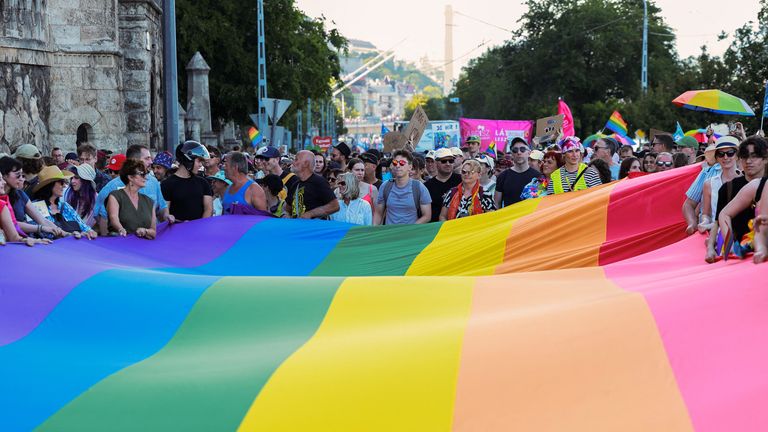 Lidé drží šestibarevný duhový banner během pochodu Budapešť Pride v Budapešti v Maďarsku, 28. června 2025. Reuters/Bernadett Szabo
