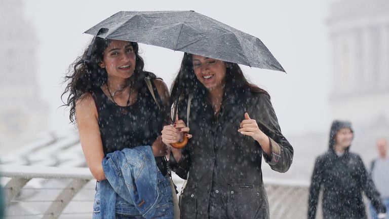 Lidé, kteří chodí podél Millennium Bridge v Londýně, během dešťové sprchy, protože Met Office vydala žluté počasí varování přes Midlands pro bouřky a jih Anglie pro silné větry. Datum obrázku: Středa 2. srpna 2023. PA foto. Foto kredit by si měl přečíst: Yui Mok/PA Wire