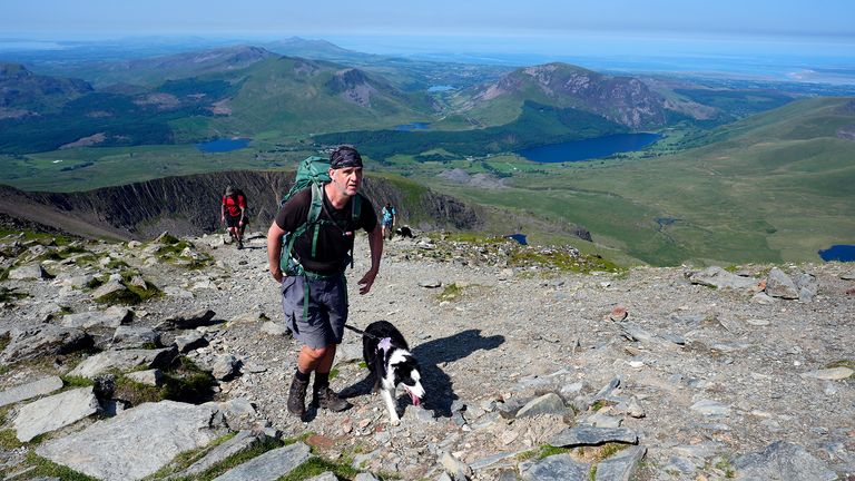 Osoba, která chodí se psem na Yr Wyddfa ve Snowdonia ve Walesu.  Pic: Pa