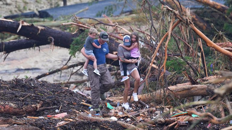 Lidé stoupají po troskách na mostě na vrcholu řeky Guadalupe po bleskové povodni. Pic: Ap