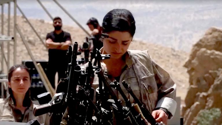 Ozbrojený bojovník PKK umístí zbraň, která má být spálena během odzbrojujícího obřadu v Sulaimaniya v Iráku.  Pic Reuters