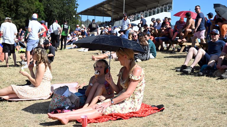 Členy veřejnosti používají deštník pro stín na slunci na festivalu Goodwood Speed, West Sussex. Pic: Pa 