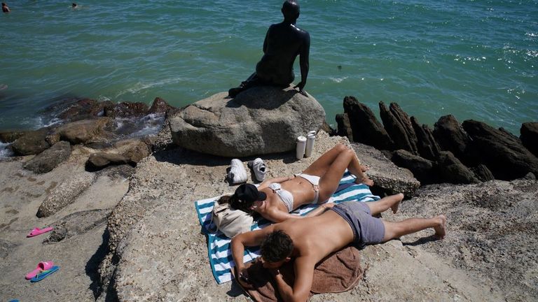 Lidé, kteří si užívají horké počasí na Sunny Sands Beach v Folkestone. Pic: Pa 