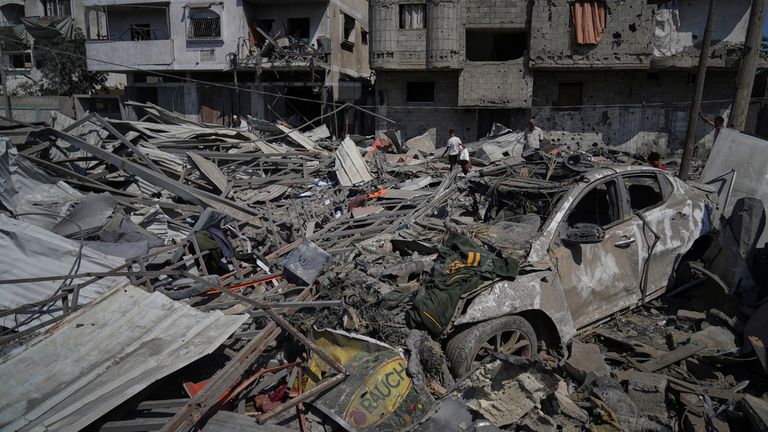 Palestinci kontrolují trosky čerpací stanice zničené v izraelském leteckém úderu v Deir al-Balah, Strip Central Gaza, sobotu 12. července 2025. (AP Photo/Abdel Kareem Hana)