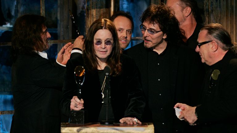   Ozzy Osboure, druhý zleva, je obklopen členy skupiny a členy Metallica, protože je uvedena Black Sabbath 