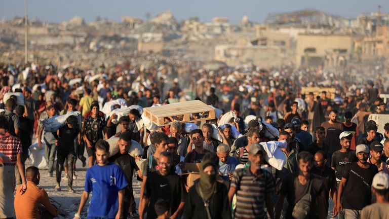 Palestinci nese pomocné zásoby, které vstoupily do Gazy přes Izrael, v Beit Lahia v pruhu severní Gazy.  Pic Reuters