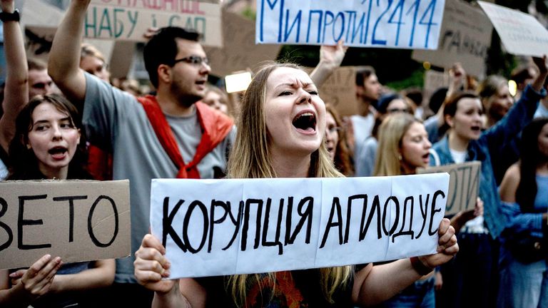   Žena drží čtení banneru "Korupce tleská". Pic: AP/ 