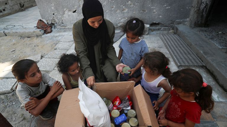 Žena s pozemkem s potravinami airdropped ve městě Gaza. Pic: Reuters
