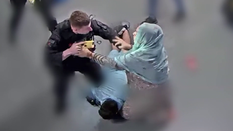 PC Zachary Marsden (vlevo dole) s konfrontováním matky obžalovaných paní Akhtar na letišti v Manchesteru