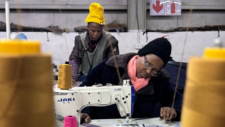 Pracovník ve vládním skladu v Maputosoe, Lesotho - 5 km od Jižní Afriky - kde ženy vyrábějí oblečení