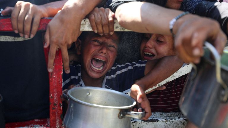 Palestinci čekají na přijetí jídla z charitativní kuchyně, uprostřed hladové krize, ve městě Gaza. Pic: Reuters