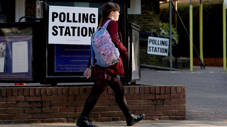 Student prochází volební stanici v Rickmansworthu v Británii, 1. května 2025. Reuters/Suzanne Plunkett