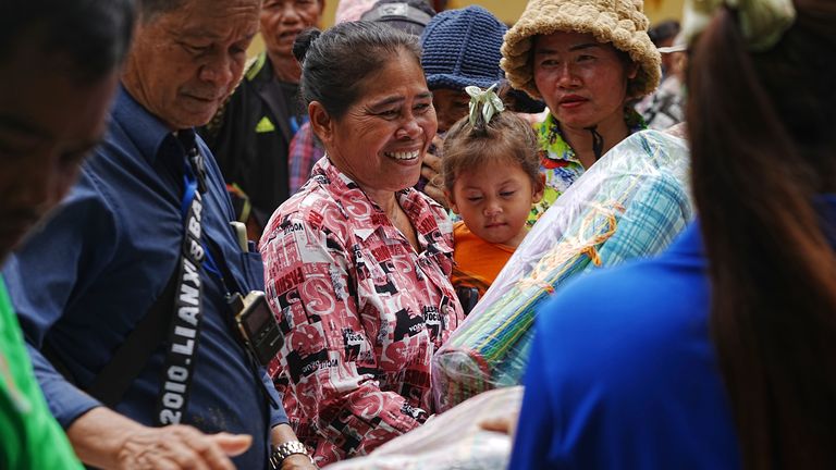 Místní vesničané dostávají zásoby poskytované charitativní organizací ve Wat Phnom Kamboar, provincii Oddar Meanchey, Kambodž, neděle 27. července 2025, uprostřed bojů mezi Thajskem a Kambodži. (AP Photo/Heng Sinith)