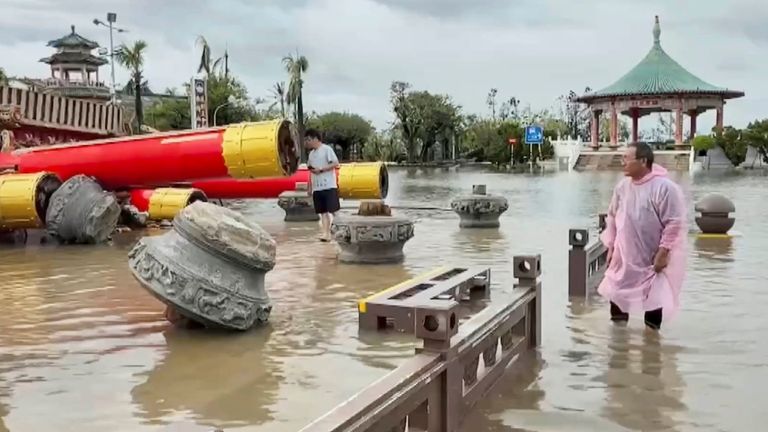 Esidents se dívají na zhroucené chrámové struktury ponořené do povodňových vod poté, co Typhoon Danas přistál v Tainanu na Tchaj -wanu.  Pic: Ap