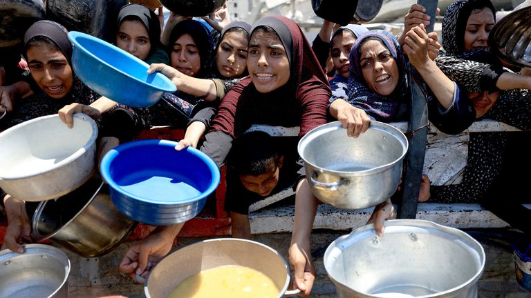 Palestinci se shromažďují, aby dostávali jídlo z charitativní kuchyně, uprostřed hladové krize v Gaze.  Pic: Reuters