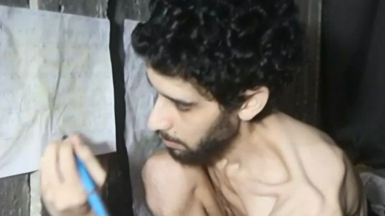 Ve videu Evyatar David píše na ručně vyrobeném kalendáři na zdi tunelu