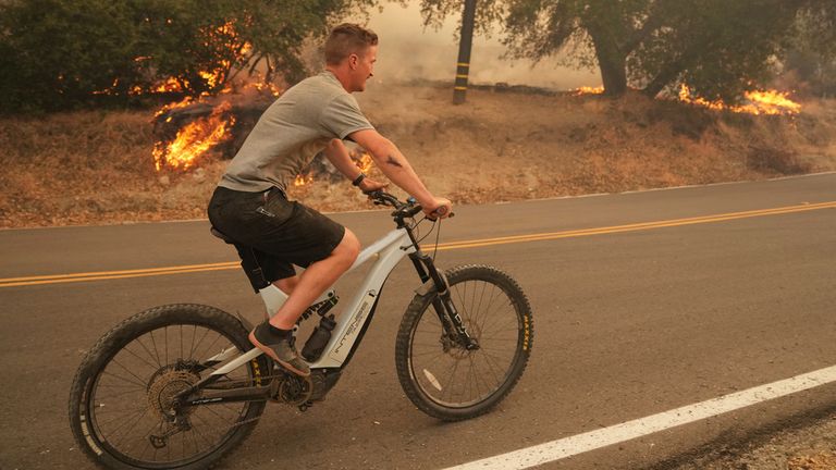 Obyvatel jezdí na kole ohněmi v Hasley Canyon. Pic: Ap