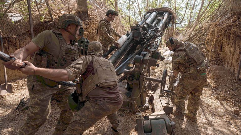 Ukrajinští vojáci 148. dělostřelecké brigádní zatížení munice do houfnice M777 před vystřelením v Zaporizhzhii. Pic: Ap