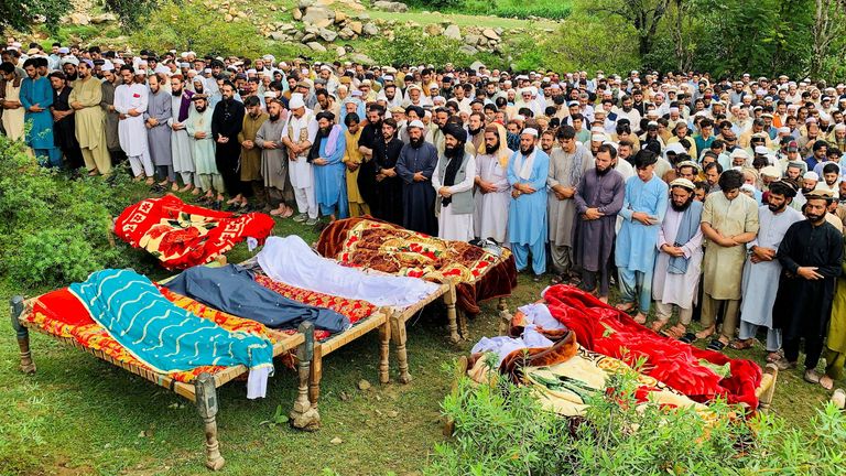 Mournery platí své opakování obětem povodní ve vesnici Jibrari v Pákistánu. Pic: Reuters