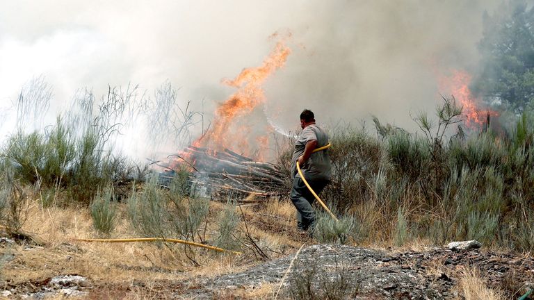 Rezident pracuje na zhasnutí požáru, který se blíží Gradiz, v Aguiar Da Beira, Portugalsko, 14. srpna 2025. Reuters/Pedro Nunes