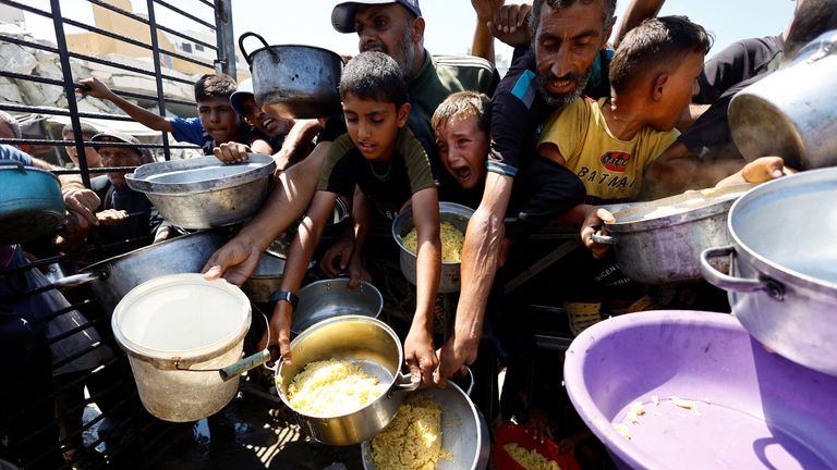 Palestinci čekají na přijetí jídla z charitativní kuchyně. Pic: Reuters