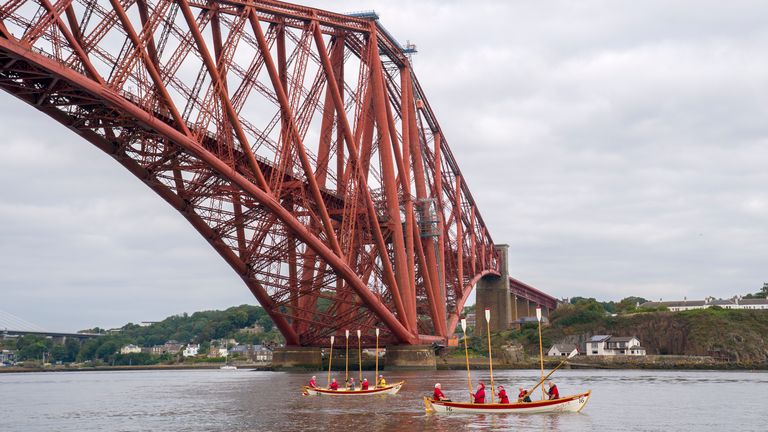 Členové klubu Queensferry Rowing Club dávají posádku Row4mnd na Forth Bridge veslo pozdravu. Pic: Pa
