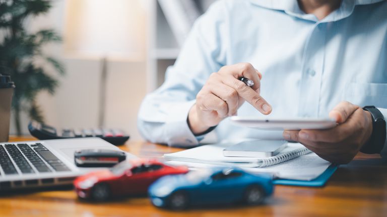 Hračky před podnikatelem výpočet půjčky. Úspora peněz na koncepci automobilů, obchodní automobily za hotovostní koncept, finanční koncept.