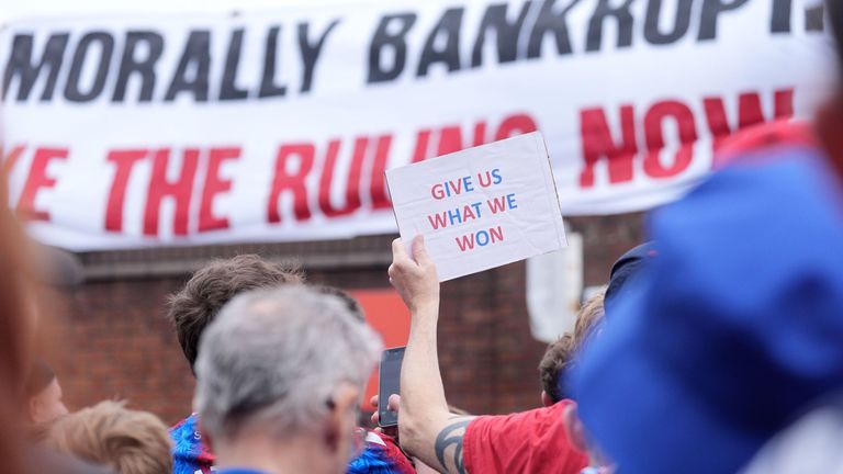 Během protestního pochodu drží fanoušek Crystal Palace, který drží znamení. Pic: Pa