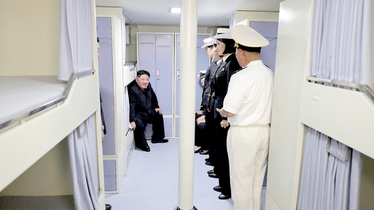 Severokorejský vůdce seděl na palandě, když mluvil s posádkou. Pic: KCNA/AP